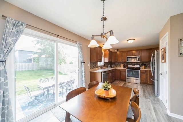 150 SE Hazelwood Dr, Waukee, IA 50263 - dining room featuring light wood finished floors and a chandelier