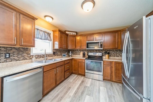 150 SE Hazelwood Dr, Waukee, IA 50263 - kitchen featuring stainless steel appliances, brown cabinets, light wood-style flooring, light countertops, and decorative backsplash