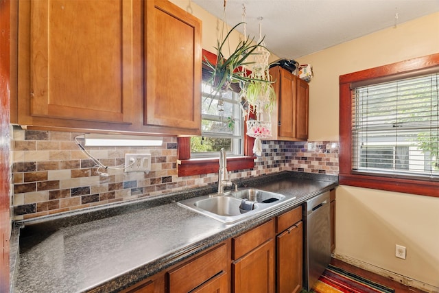 2355 Saylor Rd, Des Moines, IA 50313 - kitchen with dishwasher, dark countertops, tasteful backsplash, and brown cabinetry