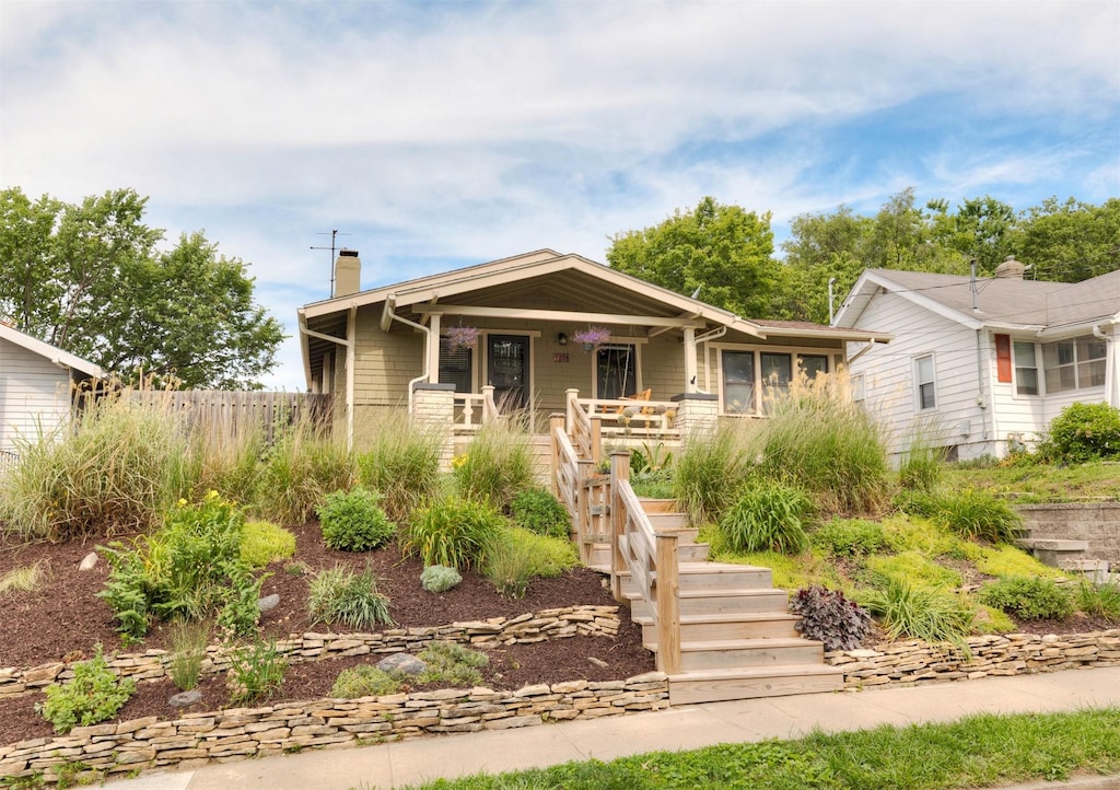 1206 47th St, Des Moines, IA 50311 - bungalow featuring a chimney, covered porch, and stairway