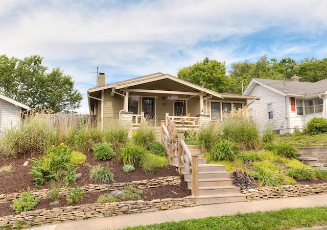 1206 47th St, Des Moines, IA 50311 - bungalow featuring a chimney, covered porch, and stairway