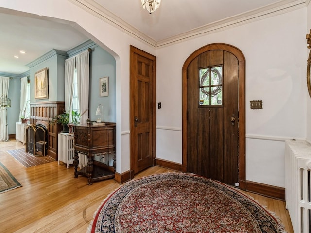 215 Foster Dr, Des Moines, IA 50312 - entryway featuring arched walkways, light wood-style floors, and crown molding