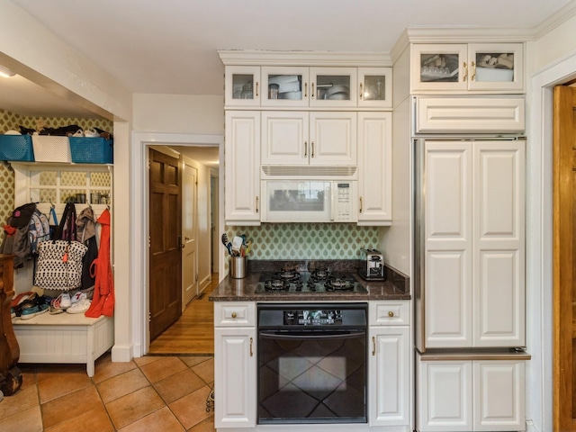 215 Foster Dr, Des Moines, IA 50312 - kitchen featuring black appliances, light tile patterned floors, white cabinets, and glass insert cabinets