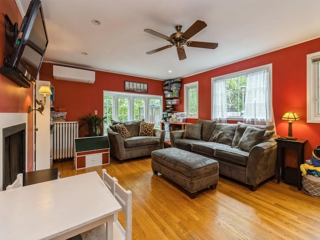 215 Foster Dr, Des Moines, IA 50312 - living area with an AC wall unit, light wood-style flooring, a ceiling fan, and a fireplace