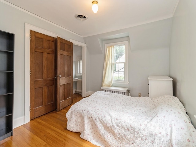 215 Foster Dr, Des Moines, IA 50312 - bedroom featuring light wood-type flooring, a closet, and radiator
