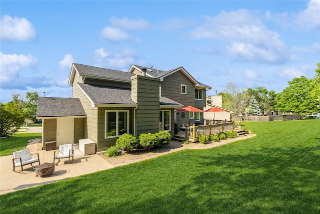281 58th Ct, West Des Moines, IA 50266 - back of property featuring a shingled roof, a fire pit, a wooden deck, a patio, and a yard