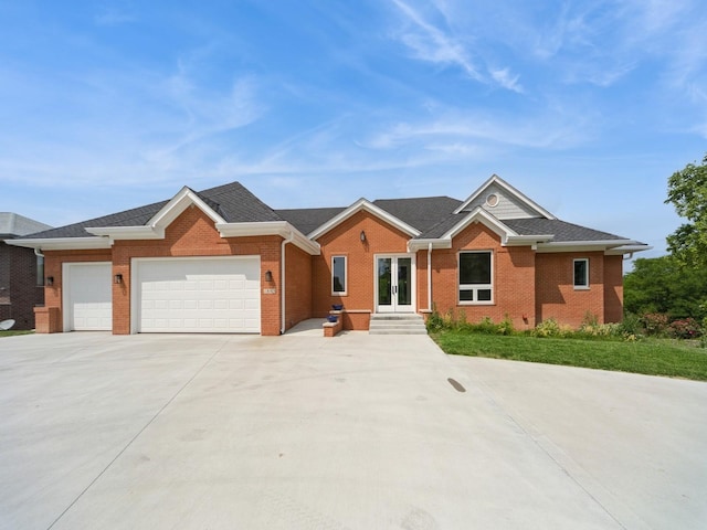 1863 Glen Oaks Dr, West Des Moines, IA 50266 - view of front of house featuring french doors, driveway, brick siding, and a garage