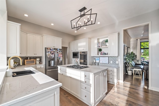 1720 Cedarwood Cir, Clive, IA 50325 - kitchen with appliances with stainless steel finishes, recessed lighting, a kitchen island, tasteful backsplash, and white cabinetry