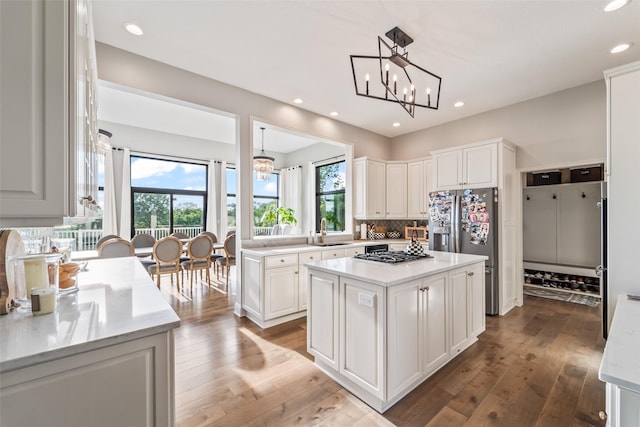 1720 Cedarwood Cir, Clive, IA 50325 - kitchen with stainless steel appliances, a chandelier, light countertops, a center island, and white cabinetry