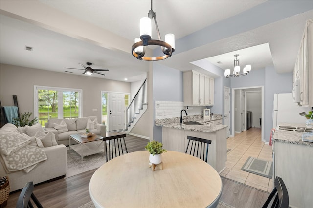 1117 S 52nd St Unit 1705, West Des Moines, IA 50265 - dining area with a chandelier, ceiling fan, and light wood-style flooring