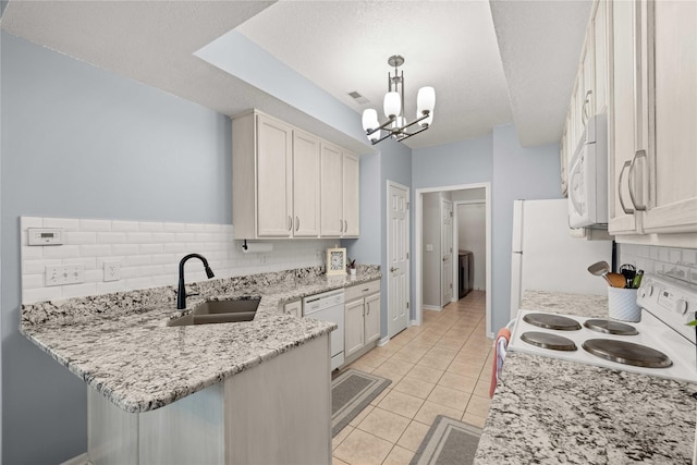 1117 S 52nd St Unit 1705, West Des Moines, IA 50265 - kitchen featuring white appliances, tasteful backsplash, a chandelier, a peninsula, and light tile patterned floors