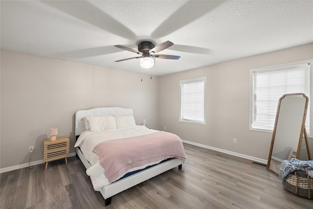 1117 S 52nd St Unit 1705, West Des Moines, IA 50265 - bedroom with wood finished floors, a textured ceiling, and a ceiling fan