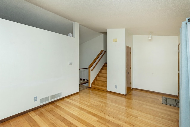 3719 SE 20th St, Des Moines, IA 50320 - unfurnished room featuring light wood finished floors, stairs, and a textured ceiling
