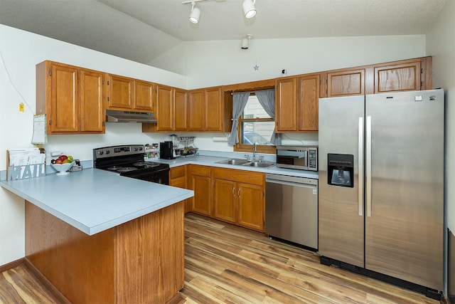 3719 SE 20th St, Des Moines, IA 50320 - kitchen featuring appliances with stainless steel finishes, under cabinet range hood, vaulted ceiling, a peninsula, and light wood-style floors