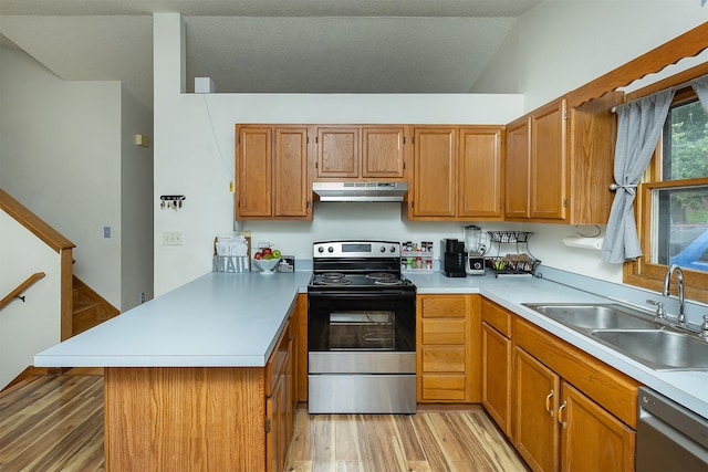 3719 SE 20th St, Des Moines, IA 50320 - kitchen with appliances with stainless steel finishes, under cabinet range hood, a peninsula, light wood-style flooring, and light countertops
