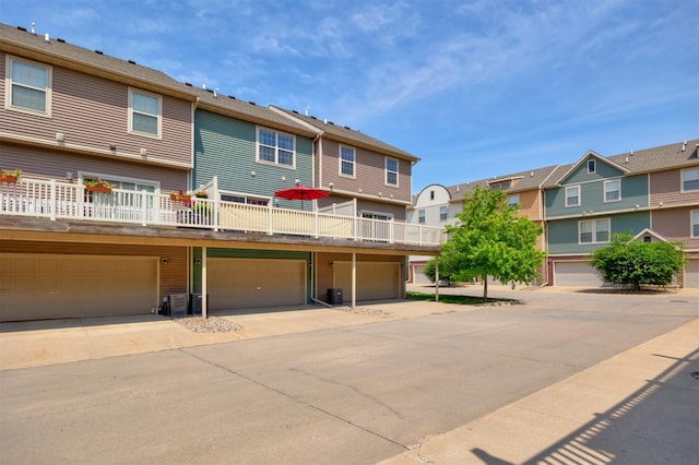 3600 SE Glenstone Dr Unit 308, Grimes, IA 50111 - rear view of house with a residential view, an attached garage, a wooden deck, and driveway