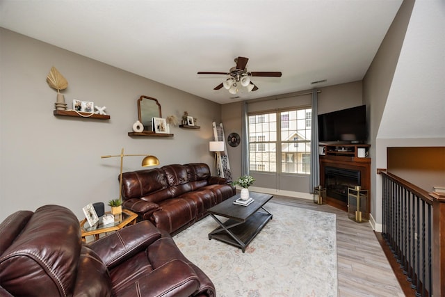 3600 SE Glenstone Dr Unit 308, Grimes, IA 50111 - living room with ceiling fan, light wood-type flooring, and a fireplace