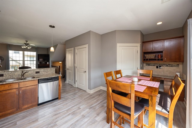 3600 SE Glenstone Dr Unit 308, Grimes, IA 50111 - kitchen featuring dishwasher, a ceiling fan, backsplash, light wood-style flooring, and light stone countertops
