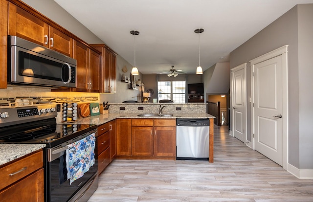 3600 SE Glenstone Dr Unit 308, Grimes, IA 50111 - kitchen featuring stainless steel appliances, a peninsula, ceiling fan, light wood finished floors, and brown cabinetry