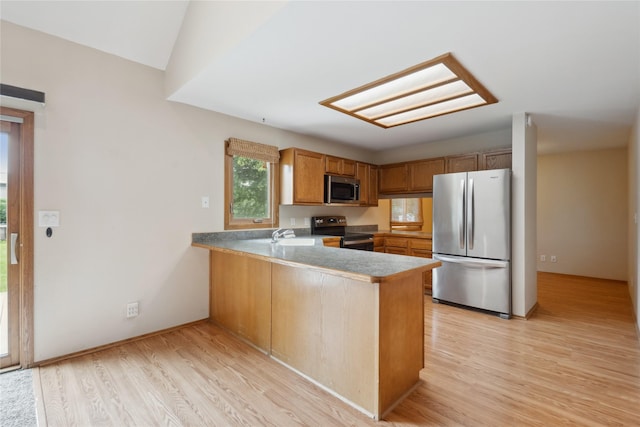 725 SE Peterson Dr, Ankeny, IA 50021 - kitchen with appliances with stainless steel finishes, a peninsula, light wood-style flooring, and brown cabinetry