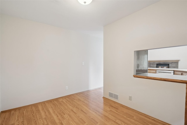 725 SE Peterson Dr, Ankeny, IA 50021 - spare room featuring wood finished floors and a stone fireplace