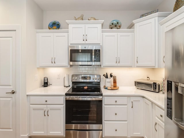 2206 SW Westwood St, Ankeny, IA 50023 - kitchen with stainless steel appliances, white cabinets, backsplash, and light countertops