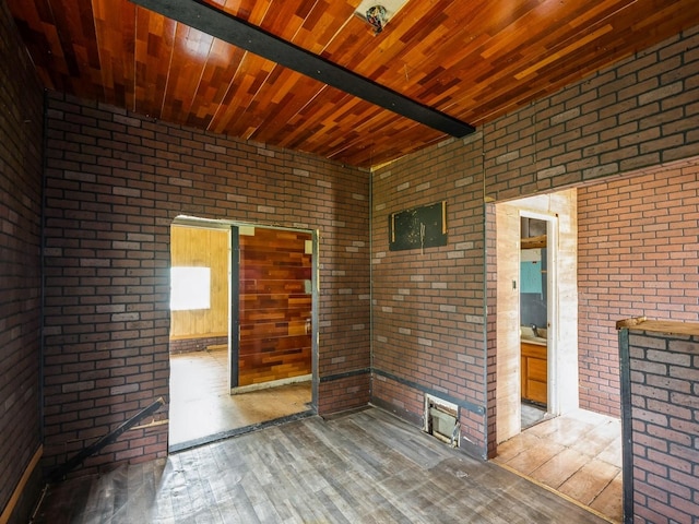 1657 Walker St, Des Moines, IA 50316 - empty room featuring brick wall, wooden ceiling, and hardwood / wood-style flooring