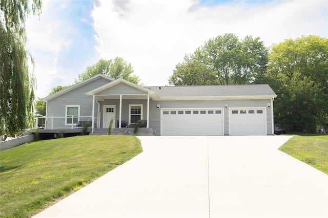 2006 10th St, Eldora, IA 50627 - view of front of property featuring concrete driveway, an attached garage, a front lawn, and a porch