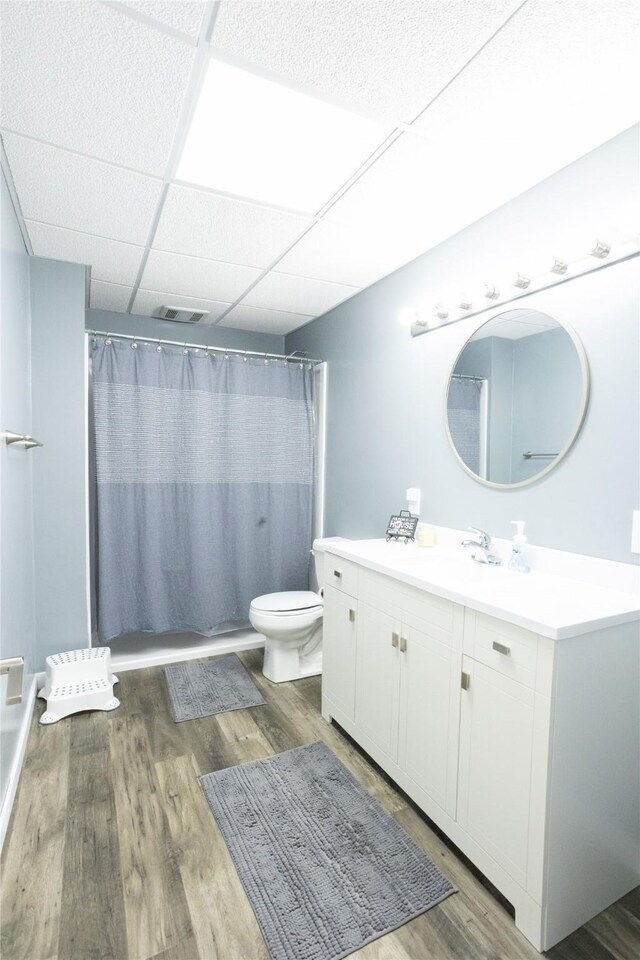2006 10th St, Eldora, IA 50627 - bathroom with vanity, wood finished floors, curtained shower, and a drop ceiling