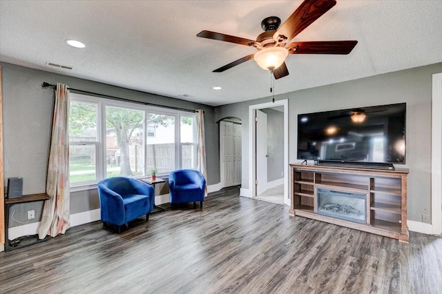 911 E 1st Ave, Indianola, IA 50125 - living room featuring wood finished floors, a textured ceiling, a ceiling fan, and recessed lighting