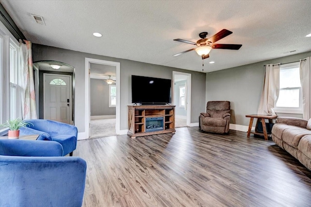 911 E 1st Ave, Indianola, IA 50125 - living area featuring a ceiling fan, a textured ceiling, wood finished floors, plenty of natural light, and recessed lighting