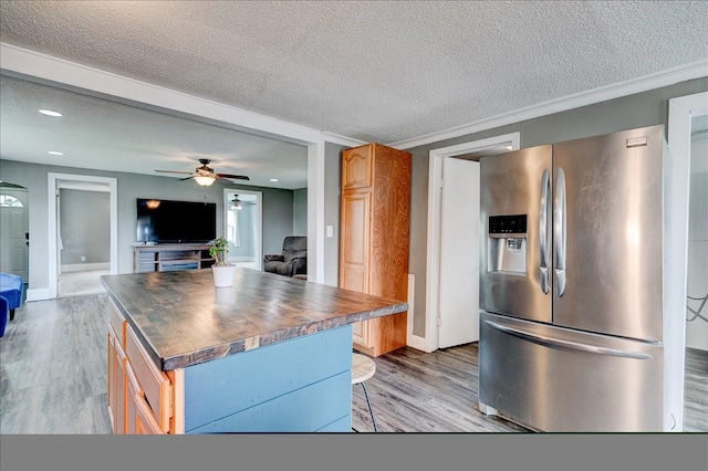 911 E 1st Ave, Indianola, IA 50125 - kitchen with stainless steel fridge with ice dispenser, light wood-style floors, a textured ceiling, open floor plan, and a ceiling fan