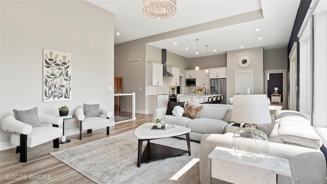 780 NE Badger Ln, Waukee, IA 50263 - living area with light wood-type flooring, a towering ceiling, and recessed lighting