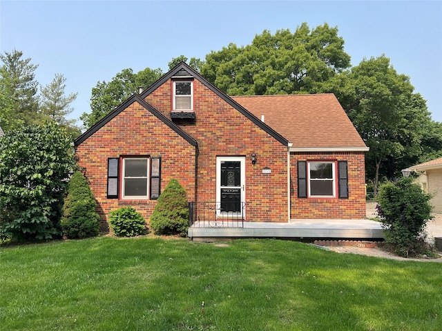 2712 49th St, Des Moines, IA 50310 - view of front of property with brick siding, a front yard, and roof with shingles