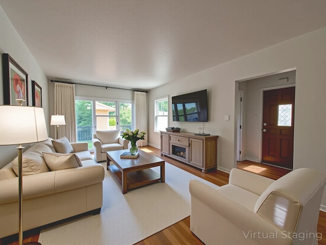 2712 49th St, Des Moines, IA 50310 - living room with wood finished floors, a fireplace, and a textured ceiling