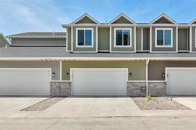 481 10th St, Waukee, IA 50263 - view of property featuring stone siding, roof with shingles, and concrete driveway