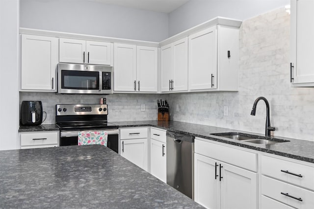 481 10th St, Waukee, IA 50263 - kitchen featuring stainless steel appliances, white cabinetry, backsplash, and dark stone countertops