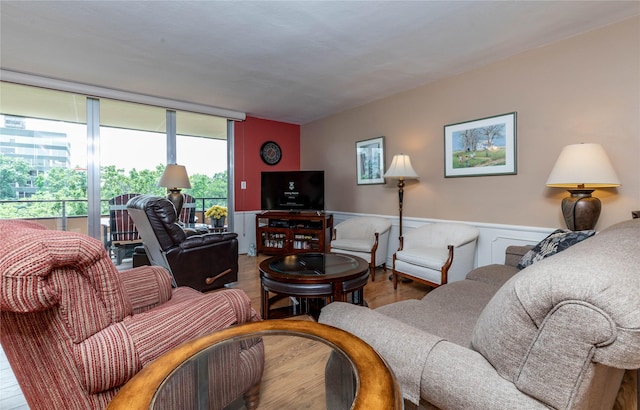 3663 Grand Ave Unit 604, Des Moines, IA 50312 - living room featuring wood finished floors, a wainscoted wall, and expansive windows