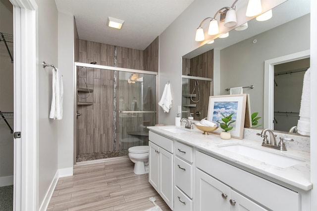 14186 Pinnacle Pointe Dr Unit 86, Clive, IA 50325 - full bath featuring a spacious closet, double vanity, a shower stall, and wood finished floors