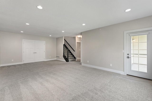 14186 Pinnacle Pointe Dr Unit 86, Clive, IA 50325 - unfurnished living room featuring stairway, recessed lighting, and carpet