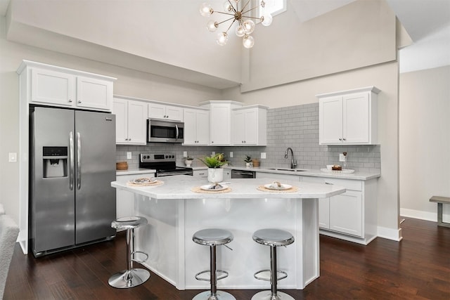14186 Pinnacle Pointe Dr Unit 86, Clive, IA 50325 - kitchen with appliances with stainless steel finishes, dark wood-style flooring, a kitchen island, white cabinetry, and light countertops