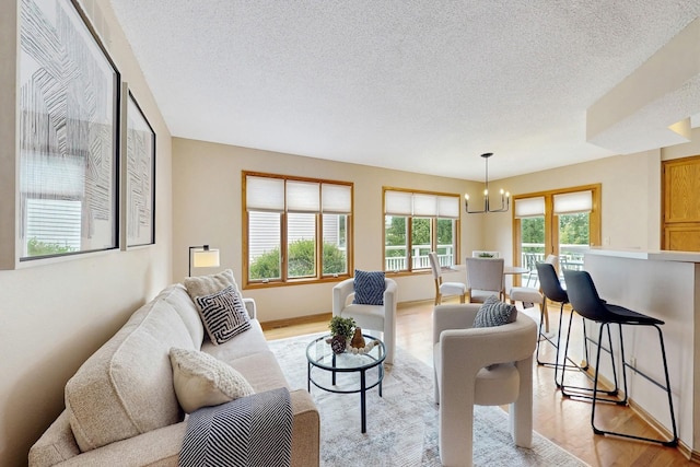 4855 Coachlight Dr, West Des Moines, IA 50265 - living area with a chandelier, light wood-style floors, and a textured ceiling