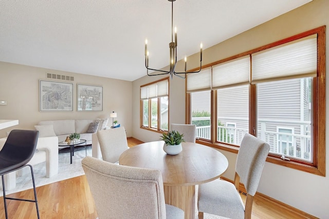 4855 Coachlight Dr, West Des Moines, IA 50265 - dining area with a chandelier and light wood-style floors