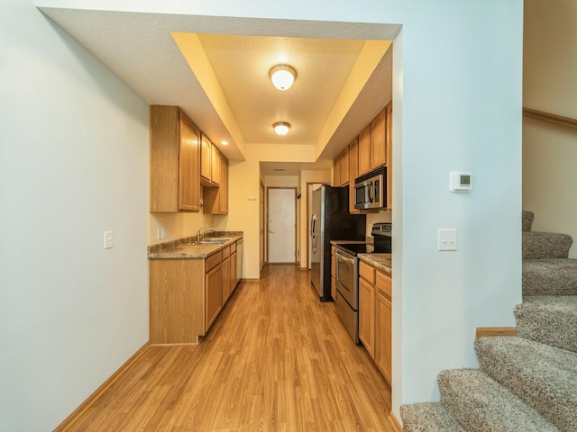 1155 NE 7th Ln, Ankeny, IA 50021 - kitchen featuring appliances with stainless steel finishes, light wood-style floors, and a tray ceiling