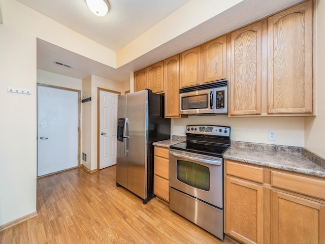 1155 NE 7th Ln, Ankeny, IA 50021 - kitchen featuring appliances with stainless steel finishes, light wood-style floors, light brown cabinets, and light countertops