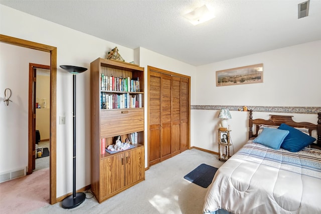 2434 SE 18th Ct, Des Moines, IA 50320 - bedroom with light carpet, a closet, and a textured ceiling