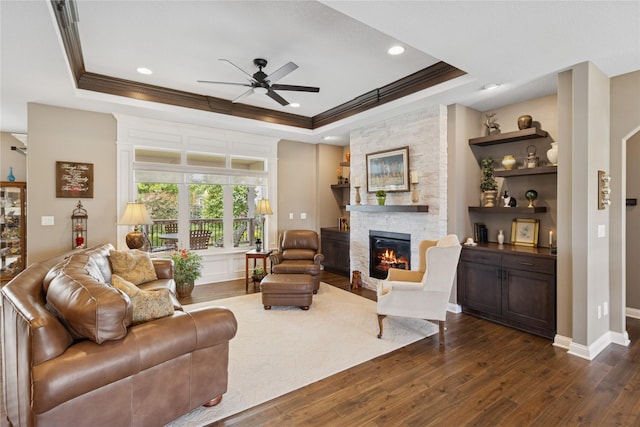 800 NE Badger Ln, Waukee, IA 50263 - living area featuring a raised ceiling, ornamental molding, ceiling fan, a fireplace, and dark wood-style floors