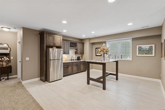 800 NE Badger Ln, Waukee, IA 50263 - kitchen featuring freestanding refrigerator, dark brown cabinets, light countertops, recessed lighting, and tasteful backsplash