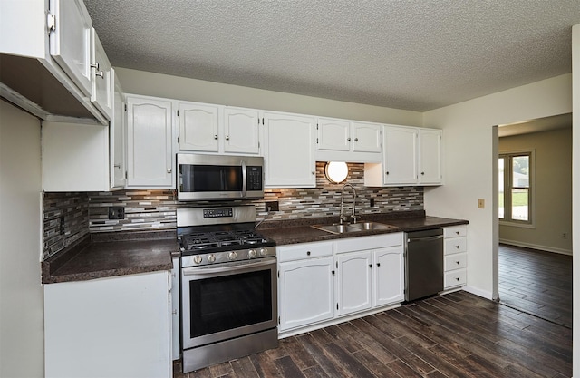 1213 NW Greenwood St, Ankeny, IA 50023 - kitchen with appliances with stainless steel finishes, dark countertops, white cabinets, dark wood-type flooring, and backsplash