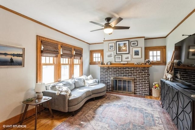 2417 Maryland Pike, Des Moines, IA 50310 - living room featuring wood finished floors, ceiling fan, crown molding, and a brick fireplace